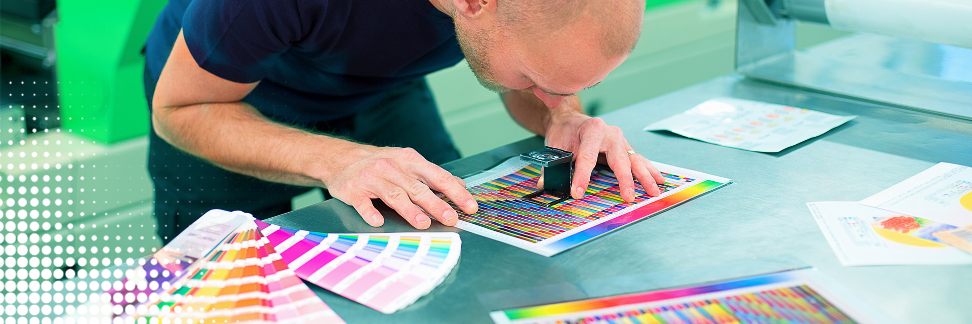 Man bekijkt met een vergrootglas de afdrukkwaliteit en kleuren in de drukkerij